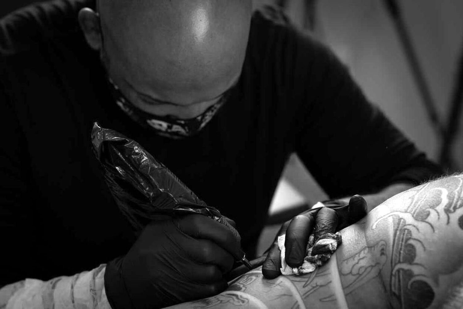 Andre Malcolm tattoo artist tattooing client